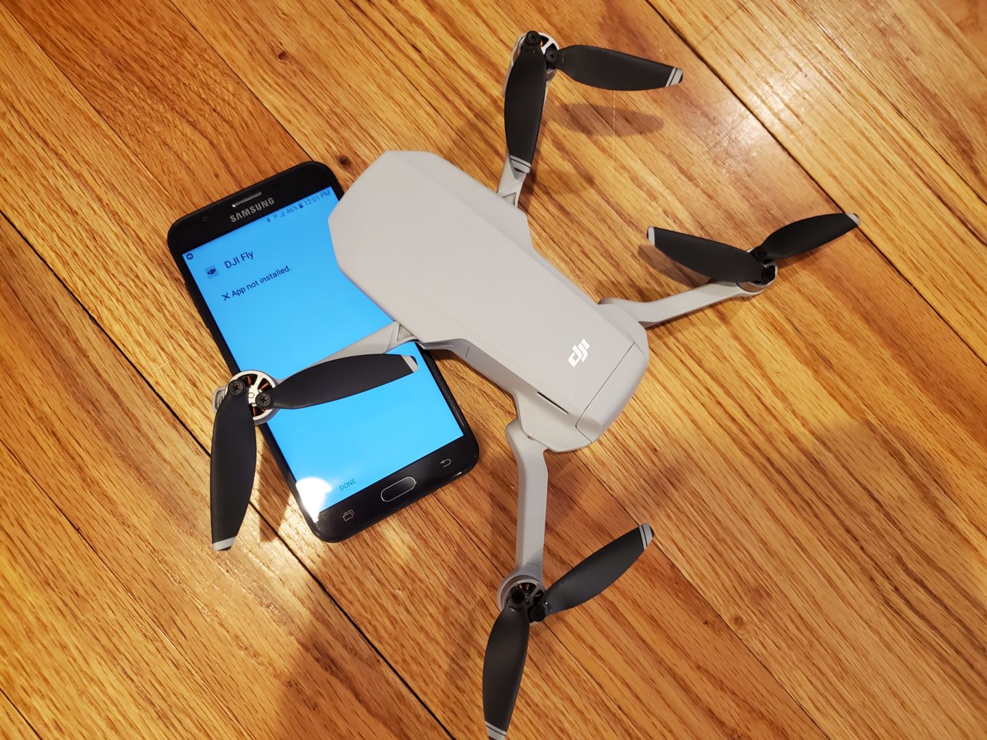 photo of the dji mavic mini with a phone showing DJI Fly app not installed
